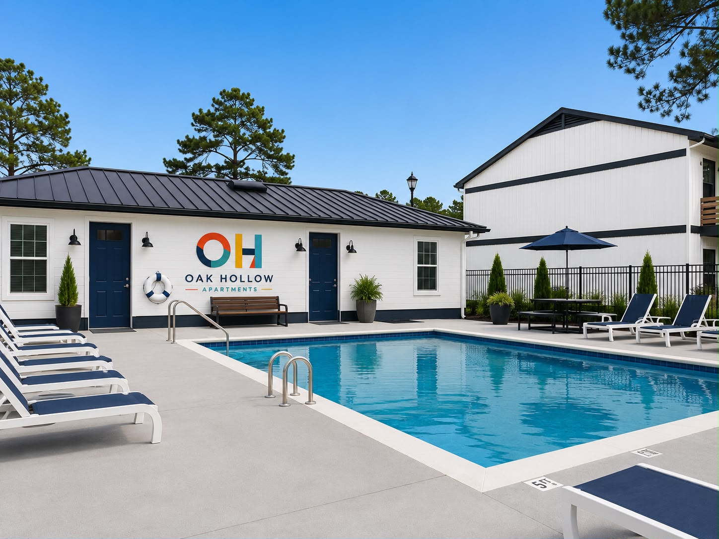 Swimming pool with lounge chairs and palm trees at Oak Hollow Apartments